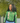 Woman wearing AKA Alpha Kappa Alpha green quarter-zip pullover with ivy pearl chest drape diagonal AKA letters and pink inner collar
