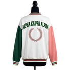 White varsity jacket with green, pink, and red accents featuring 'Alpha Kappa Alpha' on a mannequin.