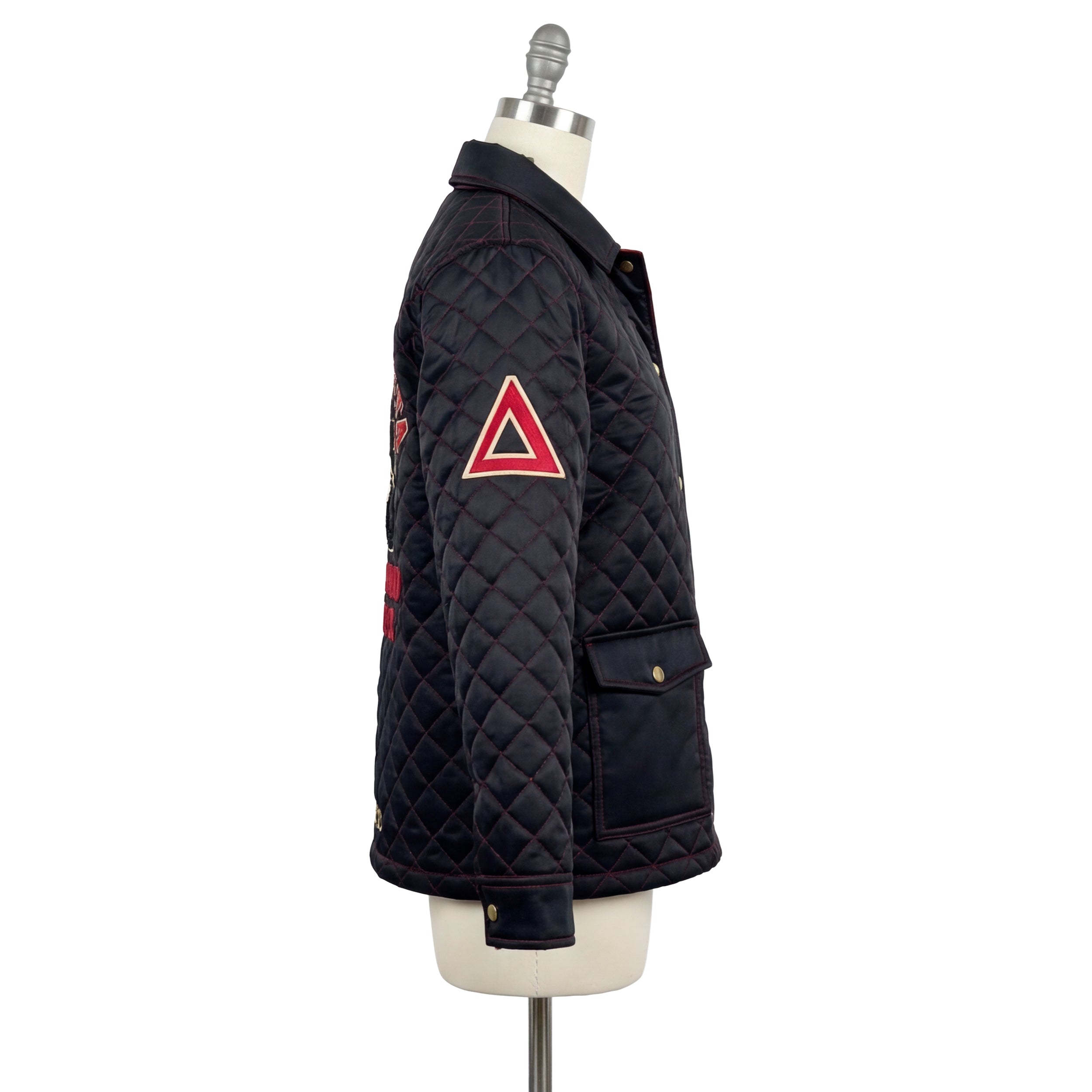 Black quilted jacket with red triangle design on a mannequin against a white background