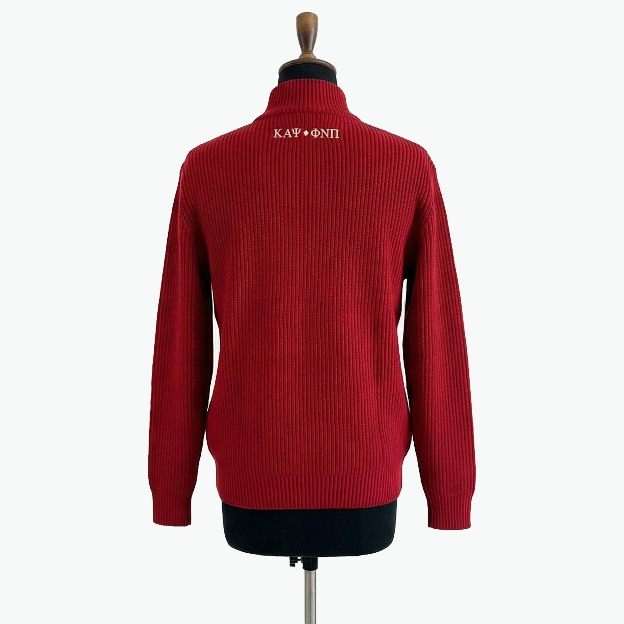 Red sweater on a mannequin with embroidered text against a white background
